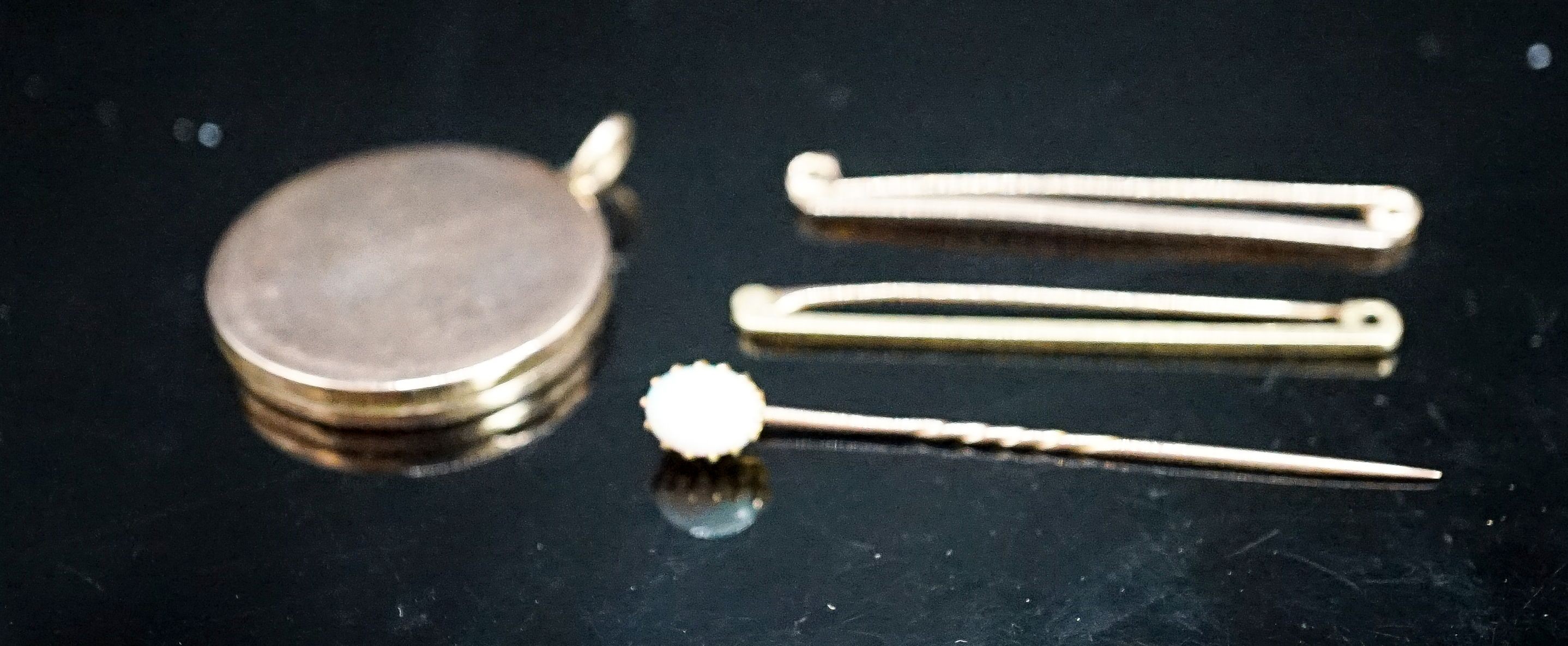 An 18ct bar brooch, 50mm, 2 grams, a 9ct bar brooch, 1.8 grams, a white opal set stick pin and a yellow metal locket.